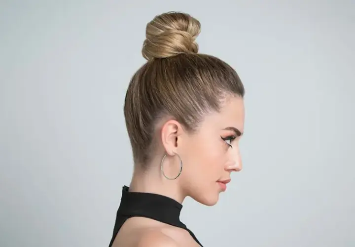 Moño alto y pulido, ideal para peinados para verano.