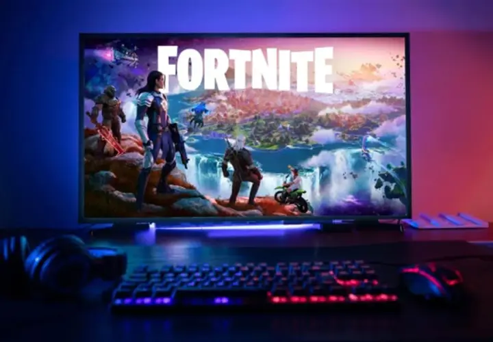 Écran affichant Fortnite avec des personnages, un clavier et une souris éclairés, prêt pour une configuration PC gaming.