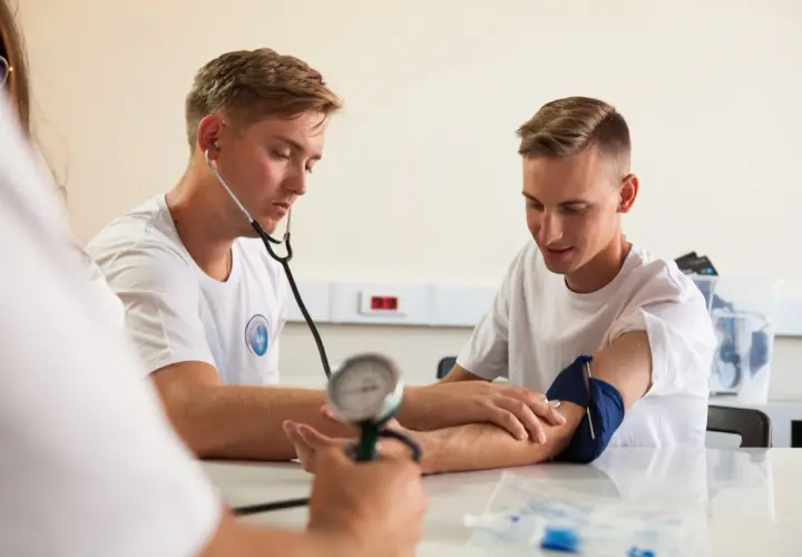 Opiekun medyczny mierzy ciśnienie, wspierając promocję zdrowia i profilaktykę.