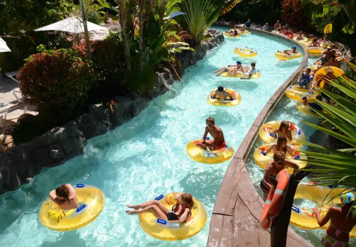 Un día perfecto de diversión en Tenerife con niños, flotando en un río artificial rodeado de vegetación exuberante.