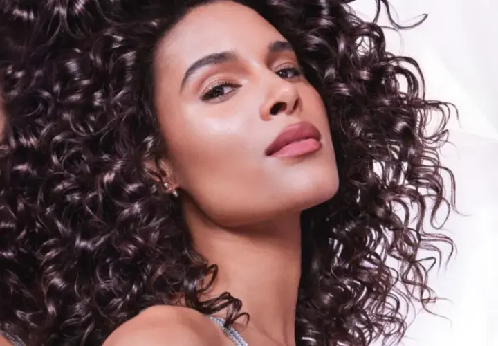 Mujer con rizos oscuros y brillantes, su piel luce radiante. El pelo opaco es un recuerdo lejano.