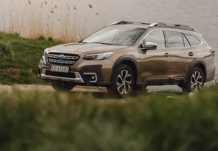 Brązowy Subaru Outback 2025 zaparkowany nad jeziorem, gotowy na przygodę.