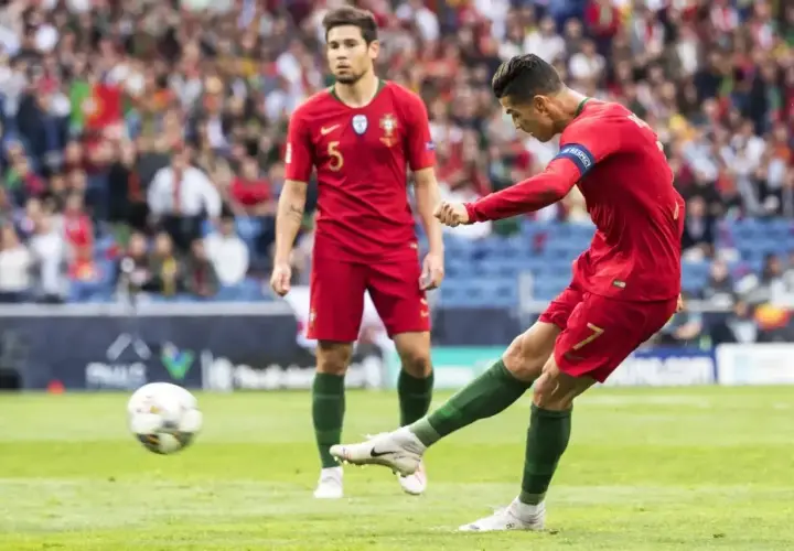Piłkarz Portugalii Cristiano Ronaldo strzela gola, podczas gdy jego kolega z drużyny obserwuje. Mecz Portugalia - Szwajcaria.