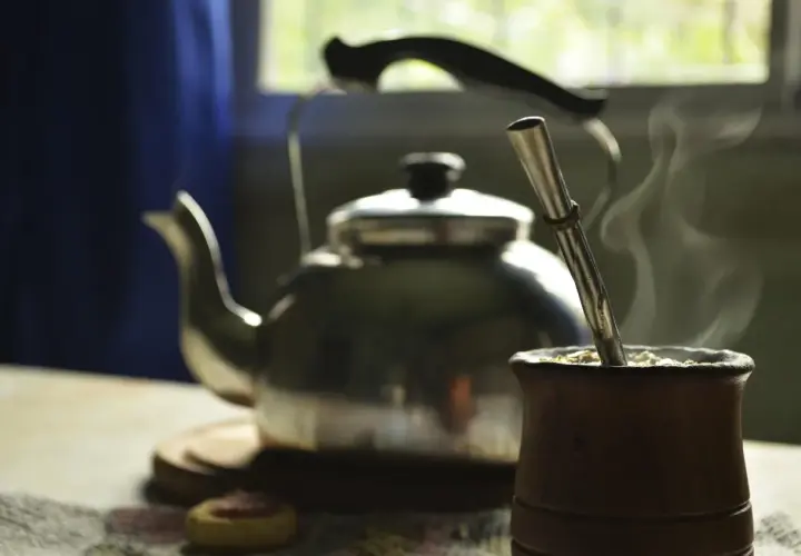 Gorąca yerba mate w drewnianym naczyniu, obok czajnik. Idealny napój, by zastanowić się, ile yerby dziennie wypić.