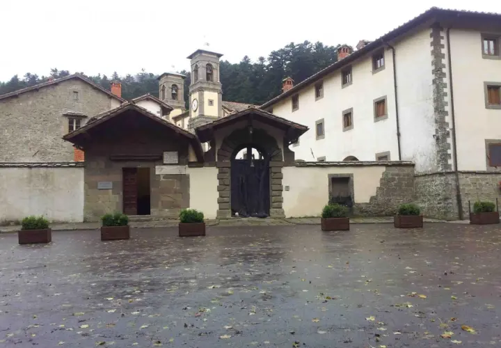 Cortile umido con foglie cadute davanti all'ingresso di Camaldoli, dove si trova questo antico eremo.