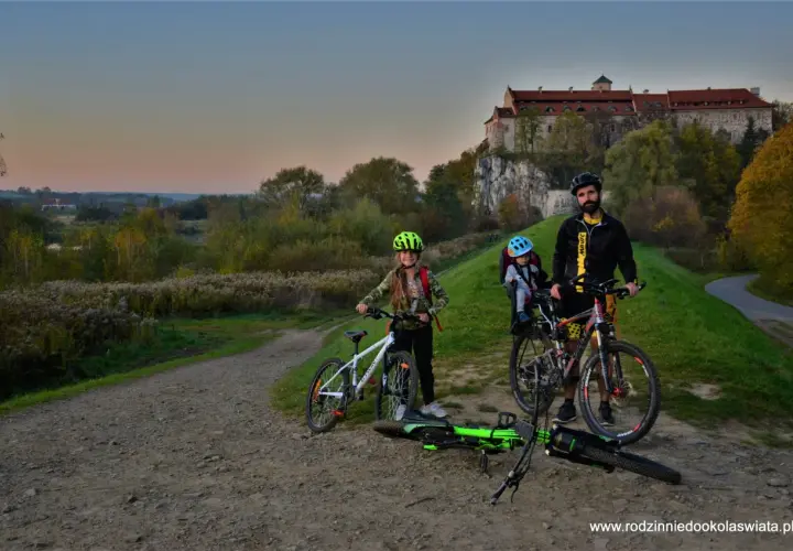 Rodzina na rowerach pod zamkiem, odkrywają malownicze trasy rowerowe Małopolska.