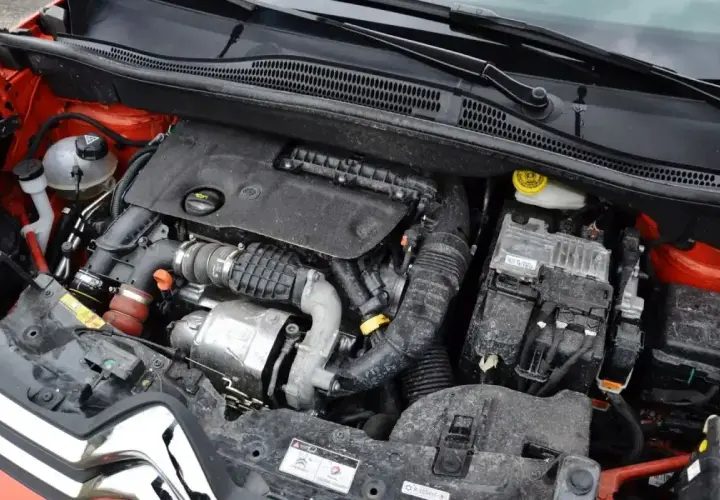 Silnik 1.6 HDI w samochodzie, widoczne elementy układu dolotowego, turbosprężarki i skrzynki bezpieczników.