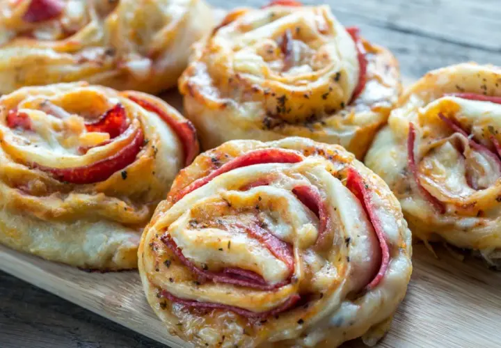 Pyszne roladki z ciasta do pizzy z serem i wędliną, idealne na przekąskę.