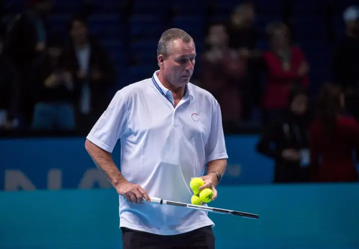 Ivan Lendl, były tenisista, trzyma rakietę i piłki tenisowe na korcie.