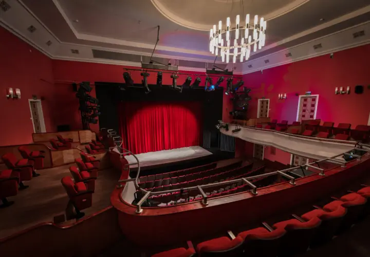 Widok na salę teatralną z czerwonymi fotelami i sceną. Teatr im. Stefana Jaracza w Łodzi czeka na widzów.