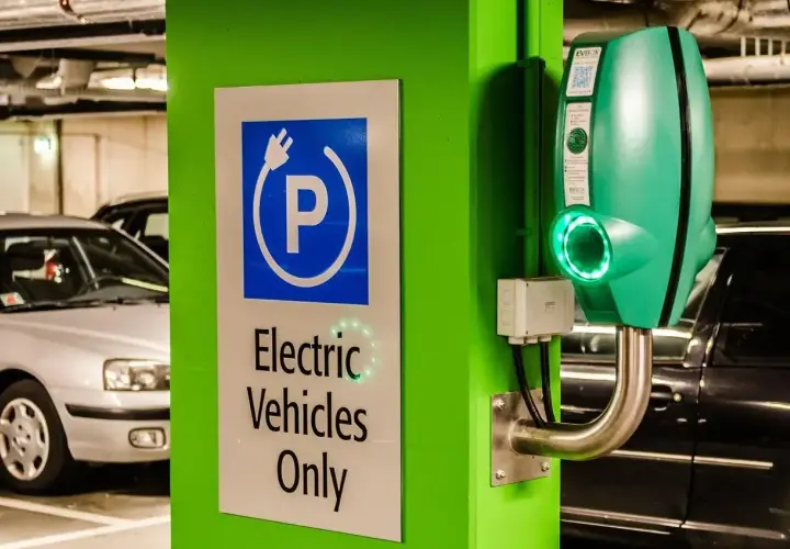Zielona ładowarka EVbox i znak "Electric Vehicles Only" w garażu podziemnym. Zastanawiasz się, ile kosztuje ładowanie samochodu elektrycznego?