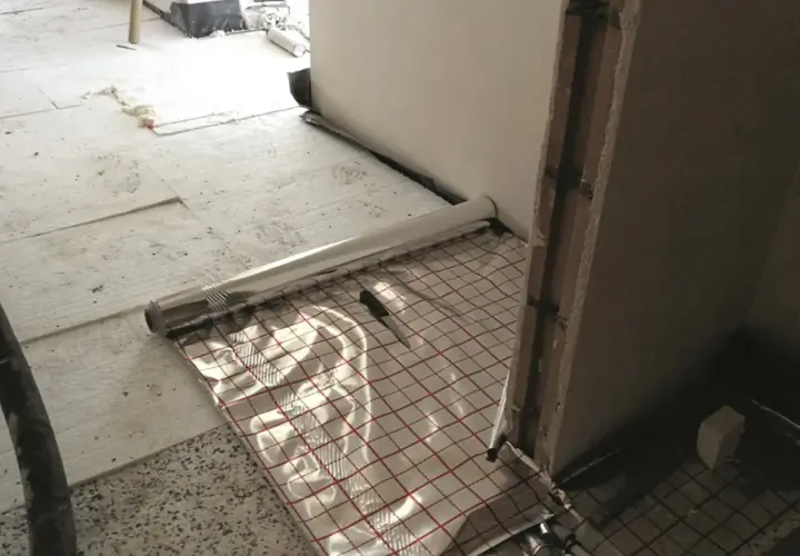 Podłoga garażowa w trakcie budowy z folią izolacyjną i siatką zbrojeniową.