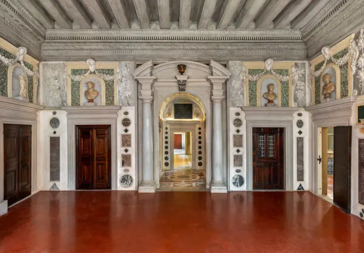 Intérieur du Palazzo Grimani, avec ses portes en bois sombres, ses bustes en marbre et ses décorations murales élaborées.