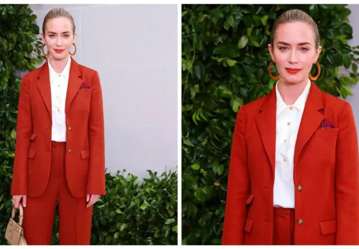 Elegancki komplet czerwony damski Emily Blunt. Aktorka prezentuje się stylowo w garniturze i białej koszuli, z torebką i okrągłymi kolczykami.