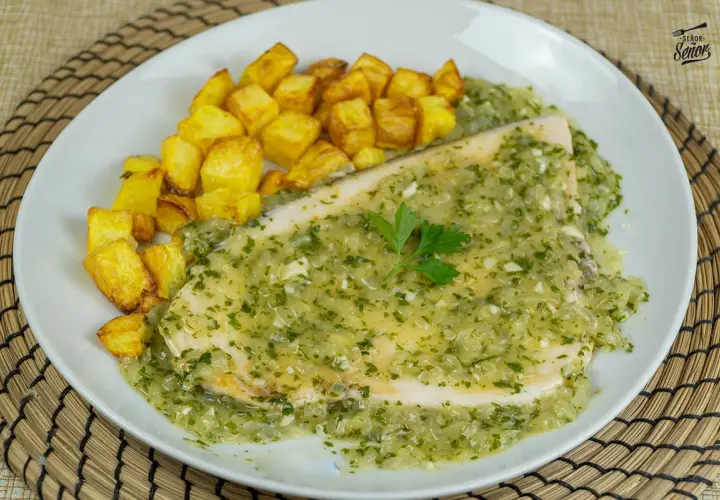 Delicioso emperador a la plancha bañado en salsa verde con patatas fritas crujientes.