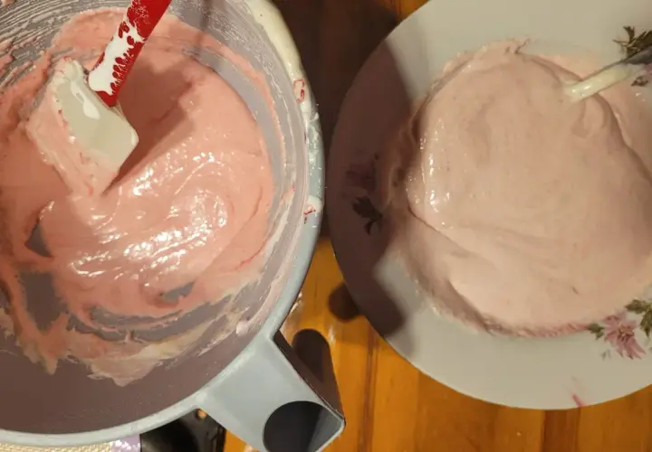 Różowy, puszysty krem do makaroników w misce i na talerzyku.