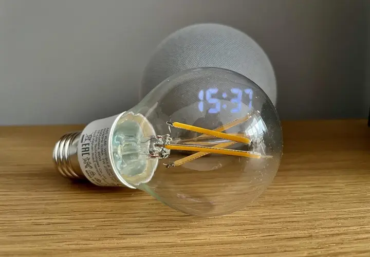 Bombilla inteligente con reloj digital y un dispositivo Echo Dot. Aprende como hacer que Alexa encienda la luz.