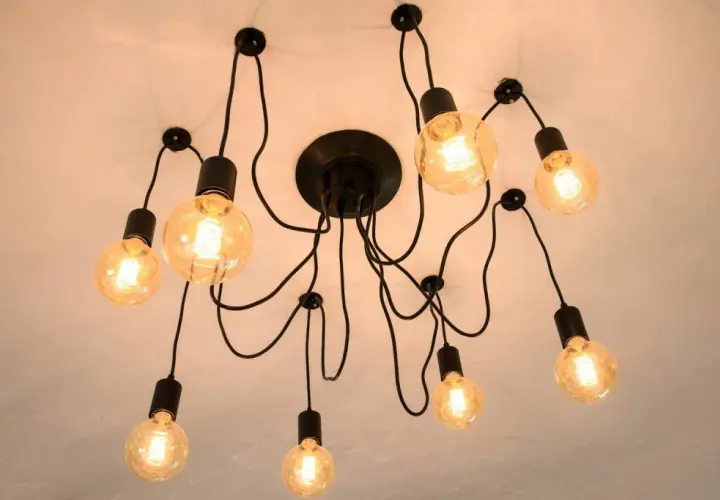 Nowoczesna lampa sufitowa z wieloma żarówkami. Dowiedz się, jak przesunąć lampę sufitową bez kucia, wykorzystując jej elastyczną konstrukcję.