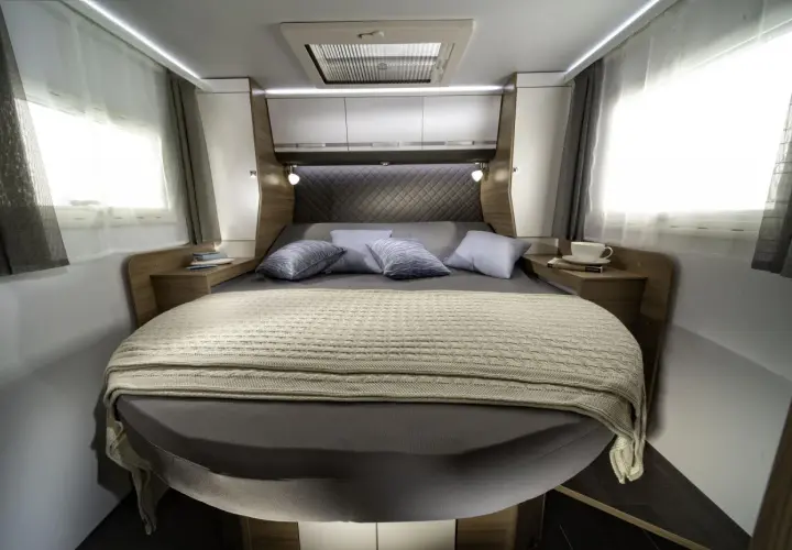Lit transversal confortable dans un camping-car, prêt pour une nuit paisible.