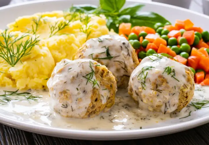 Pyszne pulpety z indyka w sosie koperkowym, podane z puree ziemniaczanym i warzywami.