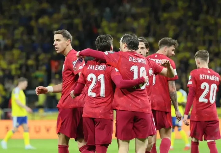 Piłkarze w czerwonych koszulkach świętują, czy polska jedzie na mundial? Zwycięstwo na boisku.