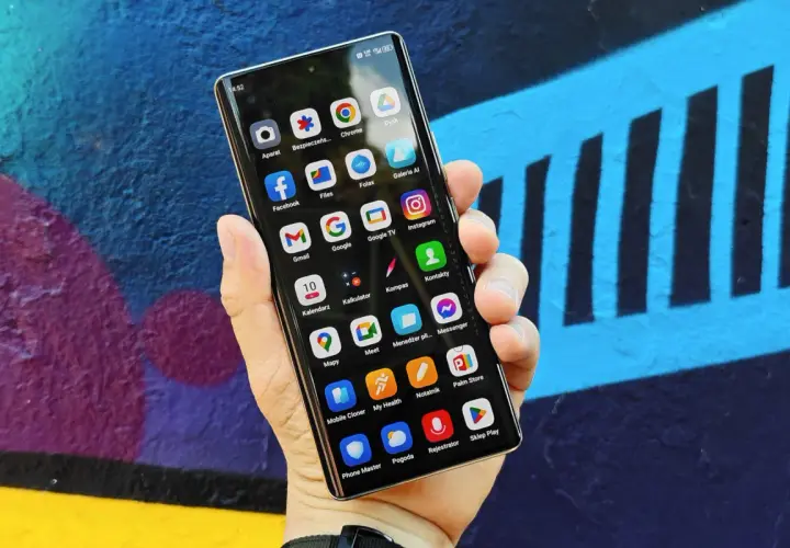 Smartfon z kolorowym tłem. Na ekranie widoczne ikony aplikacji, pomocne przy tworzeniu rankingu telefonów do 1500.
