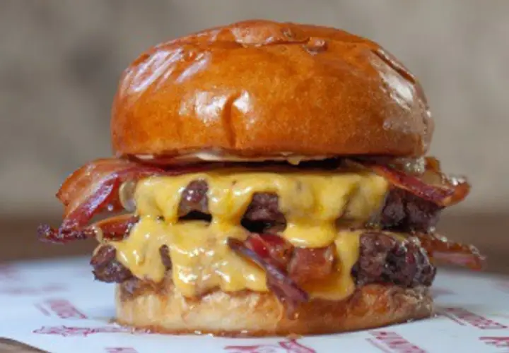Jugosa hamburguesa doble con queso fundido y crujiente bacon, un festín que vale hundred Valencia.