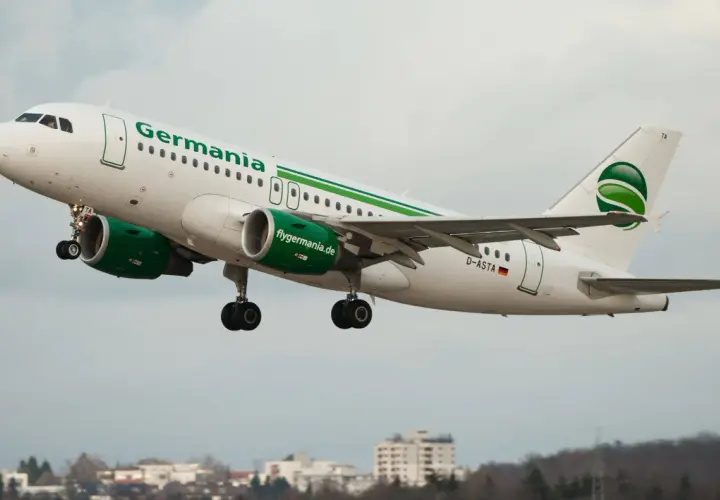 Samolot linii lotniczych Germania z zielonym logo startuje na tle pochmurnego nieba.
