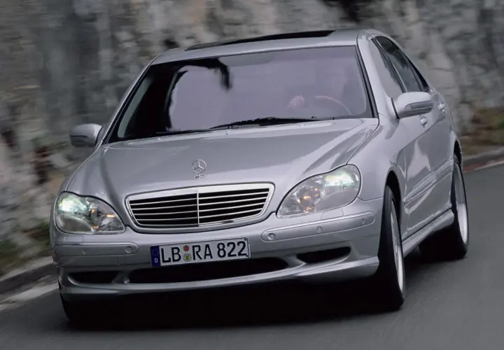 Mercedes plateado en movimiento, con el conductor visible. El sistema Airmatic parece funcionar perfectamente.