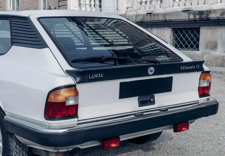Tylna część białego Lancia Gamma Coupe z czarnym spoilerem i napisem "H.P.Executive VX".