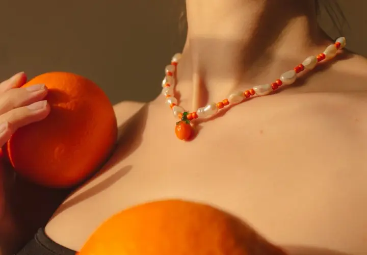 Collar de perlas y cuentas naranjas con un colgante de mandarina, como si fuera un sueño con naranjas.