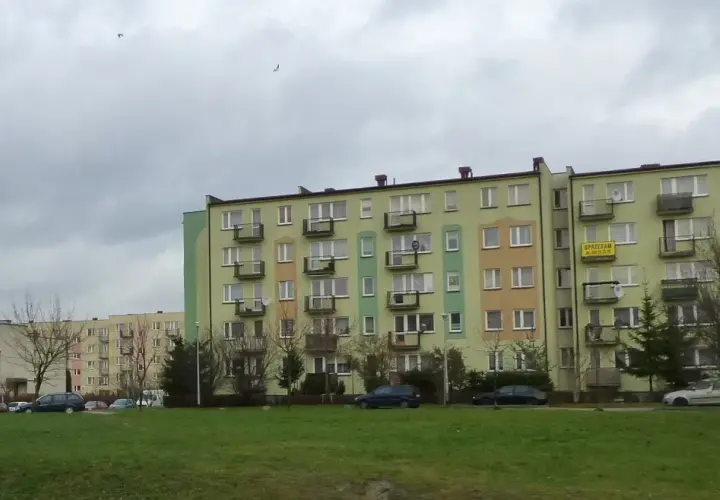 Bloki mieszkalne w Łodzi, z widocznym szyldem "SPRZEDAM". Ceny mieszkań w Łodzi mogą być różne, ale te budynki wyglądają na typowe dla osiedli z lat 70.