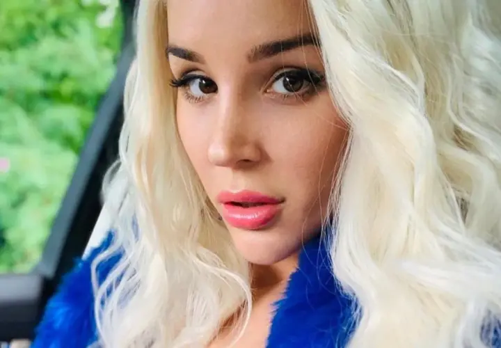 Blondynka w niebieskim futrze, zmysłowe spojrzenie. Ile lat ma sexmasterka? Trudno zgadnąć, wygląda młodo i pięknie.
