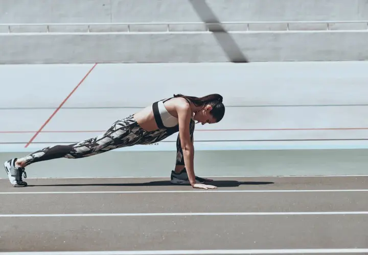 Kobieta wykonuje ćwiczenie typu stretching na bieżni.