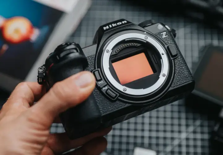 Dłoń trzyma aparat Nikon Z z widocznym sensorem.