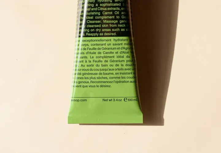 Zieleń tubki z tekstem w języku angielskim i francuskim. Analiza składu wskazuje na geranium, cytrusy i marchew.