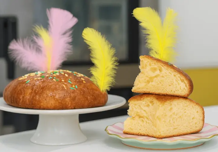 Deliciosa receta mona de pascua esponjosa, decorada con plumas de colores y chispas. ¡Perfecta para compartir!