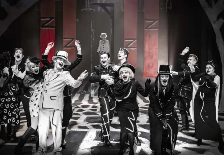 Aktorzy w teatralnych strojach, z mocnym makijażem, na scenie. Spektakl z repertuaru Teatru Starego w Krakowie.