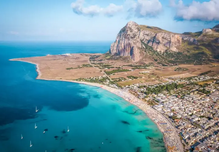 Stunning Sicily coastline with a vibrant beach and town. Do you need a car in Sicily to explore this beauty?