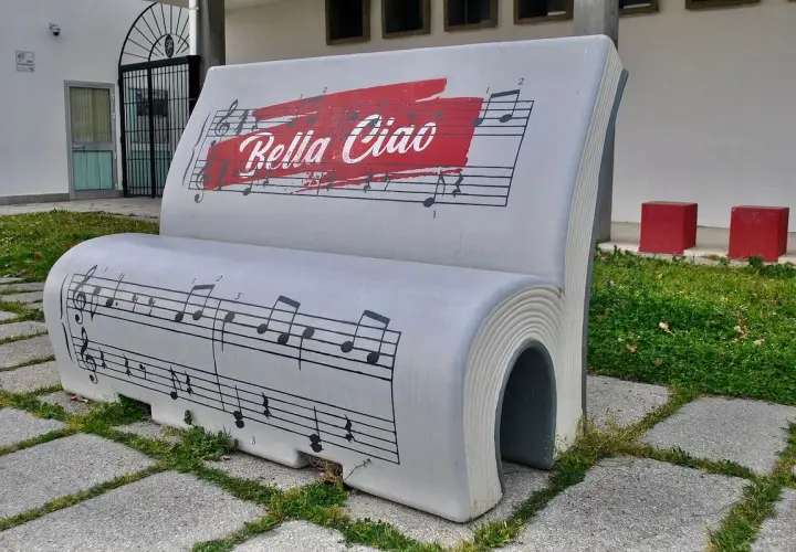 Ławka w kształcie książki z nutami i napisem "Bella Ciao tekst".
