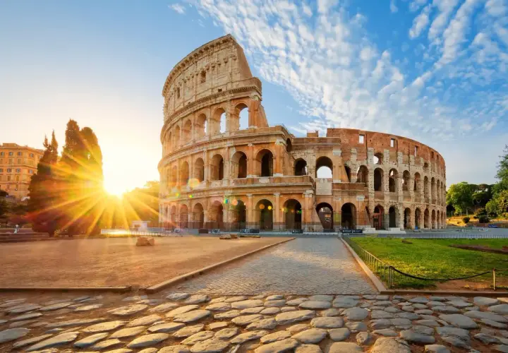 Il Colosseo all'alba, con i raggi del sole che illuminano l'anfiteatro. Vicino alla fermata metro Colosseo, linea B.