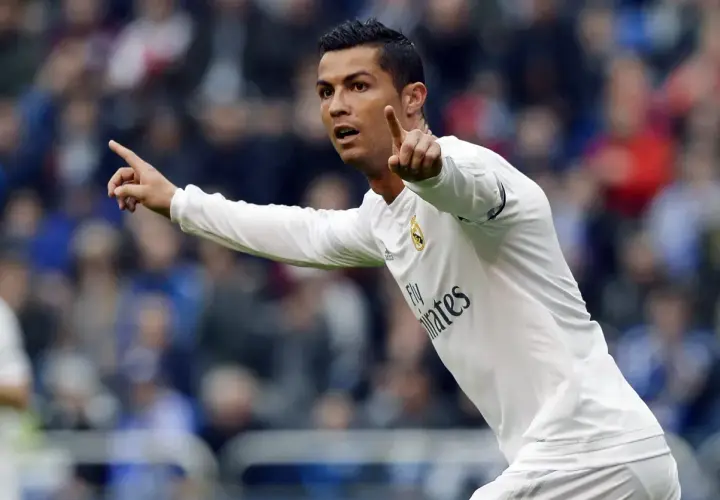 Cristiano Ronaldo w białej koszulce Realu Madryt, z uniesionymi palcami, jakby ogłaszał swój wzrost.