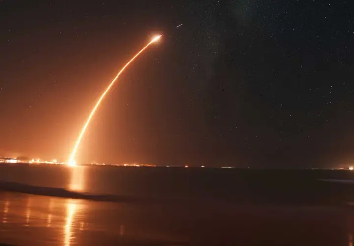 Jasny smug ognia rakiety przecina nocne niebo pełne gwiazd, ukazując, skąd startują statki kosmiczne NASA.