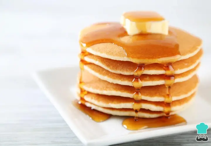 Pila de panqueques esponjosos con mantequilla y miel, perfecta para tu próxima receta.