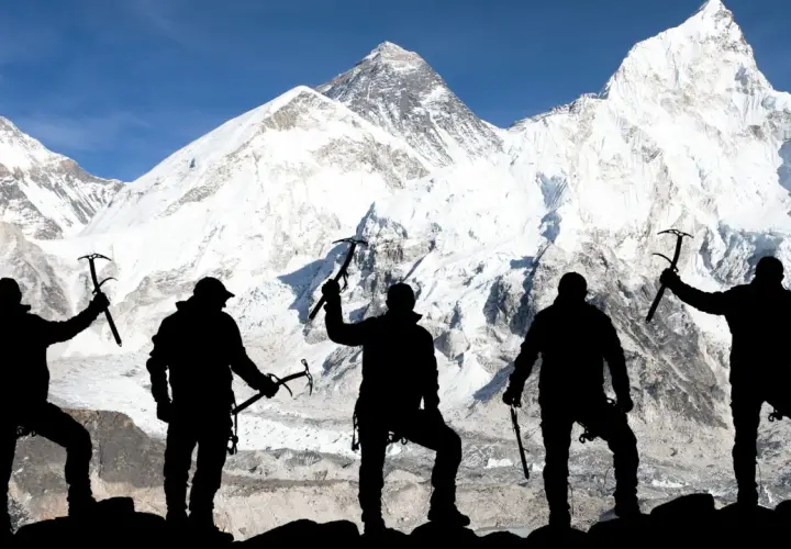 Pięciu alpinistów z czekanami na tle ośnieżonego Mount Everestu. To symboliczne przedstawienie, bo ile osób weszło na Mount Everest, to już inna historia.