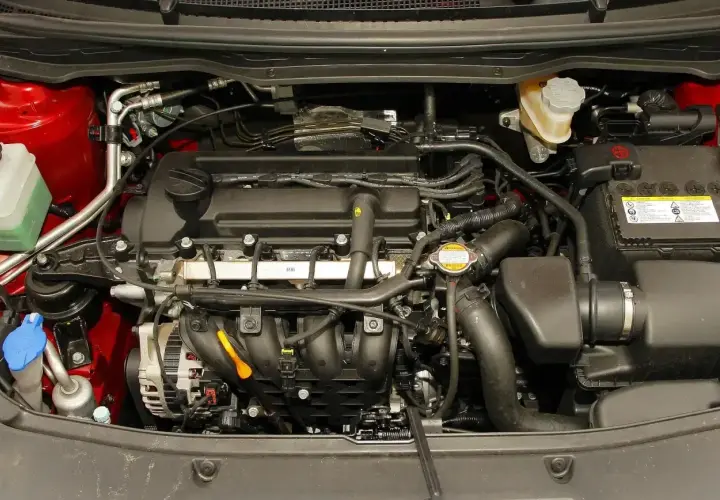 Silnik Hyundai i20 2010. Widoczny alternator, akumulator, płyny i przewody.