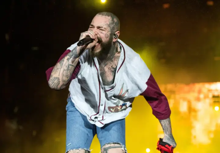 Post Malone Polska na koncercie, śpiewa z pasją w koszulce z Królikiem Bugsem i dżinsowych szortach.