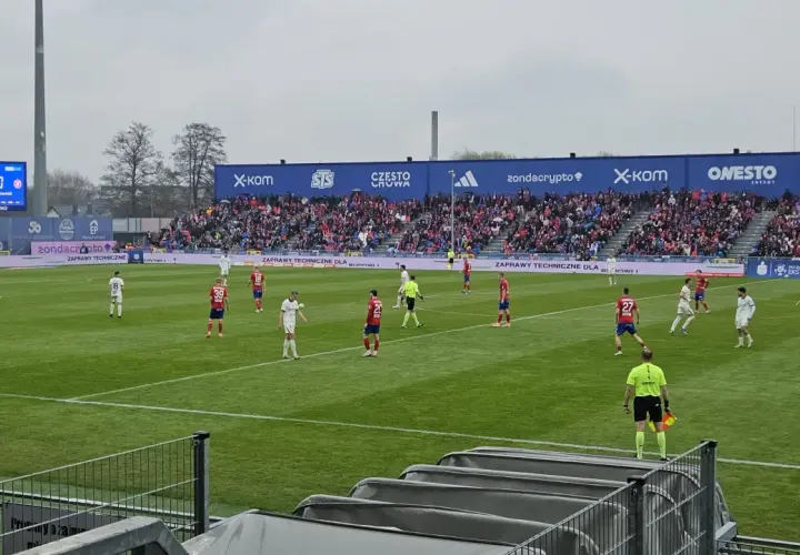 Mecz Raków Częstochowa – Widzew Łódź. Piłkarze na boisku, wynik 0:0, trybuny wypełnione kibicami.