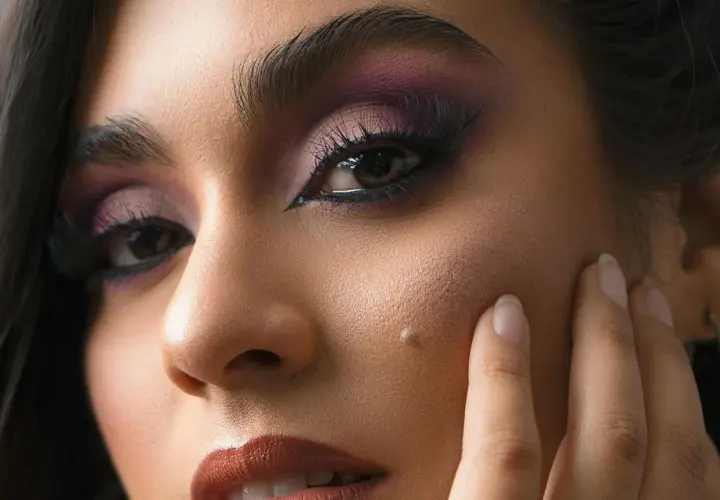 Un regard intense avec un maquillage des yeux en noir, rehaussé de fard à paupières violet.