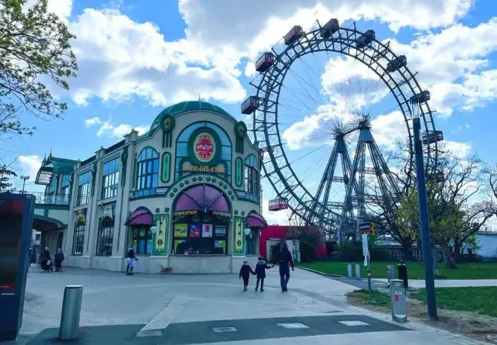 Una famiglia passeggia verso la ruota panoramica del Prater, un'attrazione iconica per una gita a Vienna con i bambini.